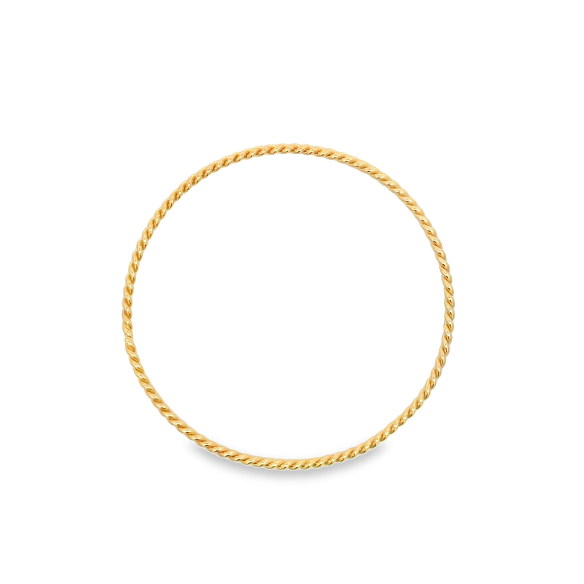 A sleek, twisted gold ring lies flat on a clean white background.