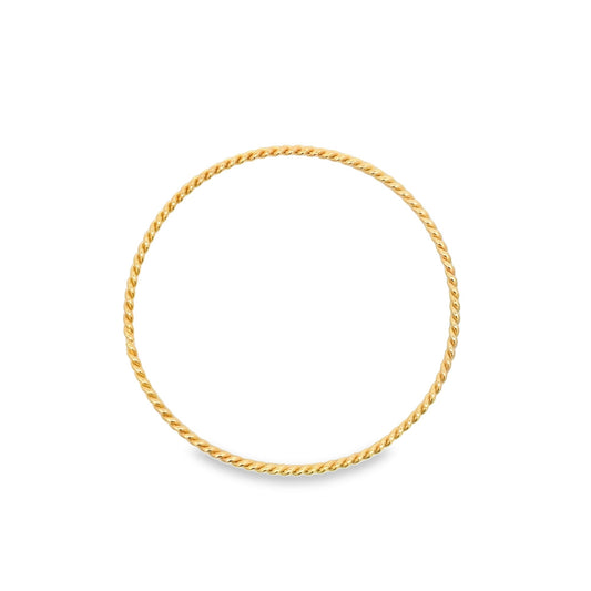 A minimalist gold twisted rope ring rests on a clean white background.