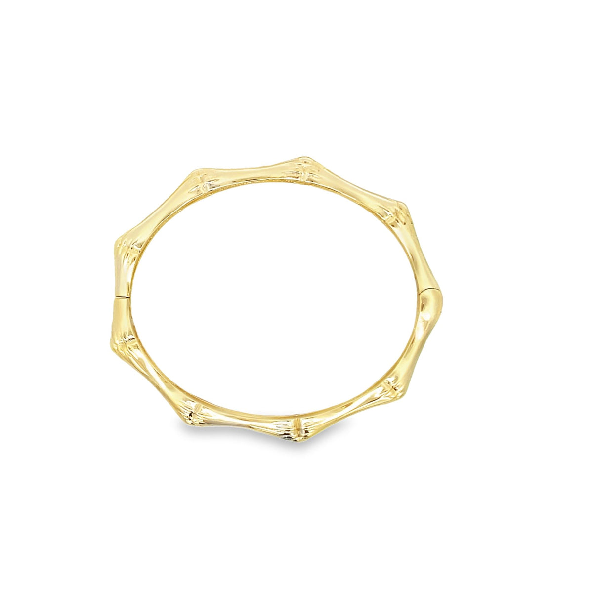 A polished gold bamboo-style bangle bracelet rests on a clean white background.