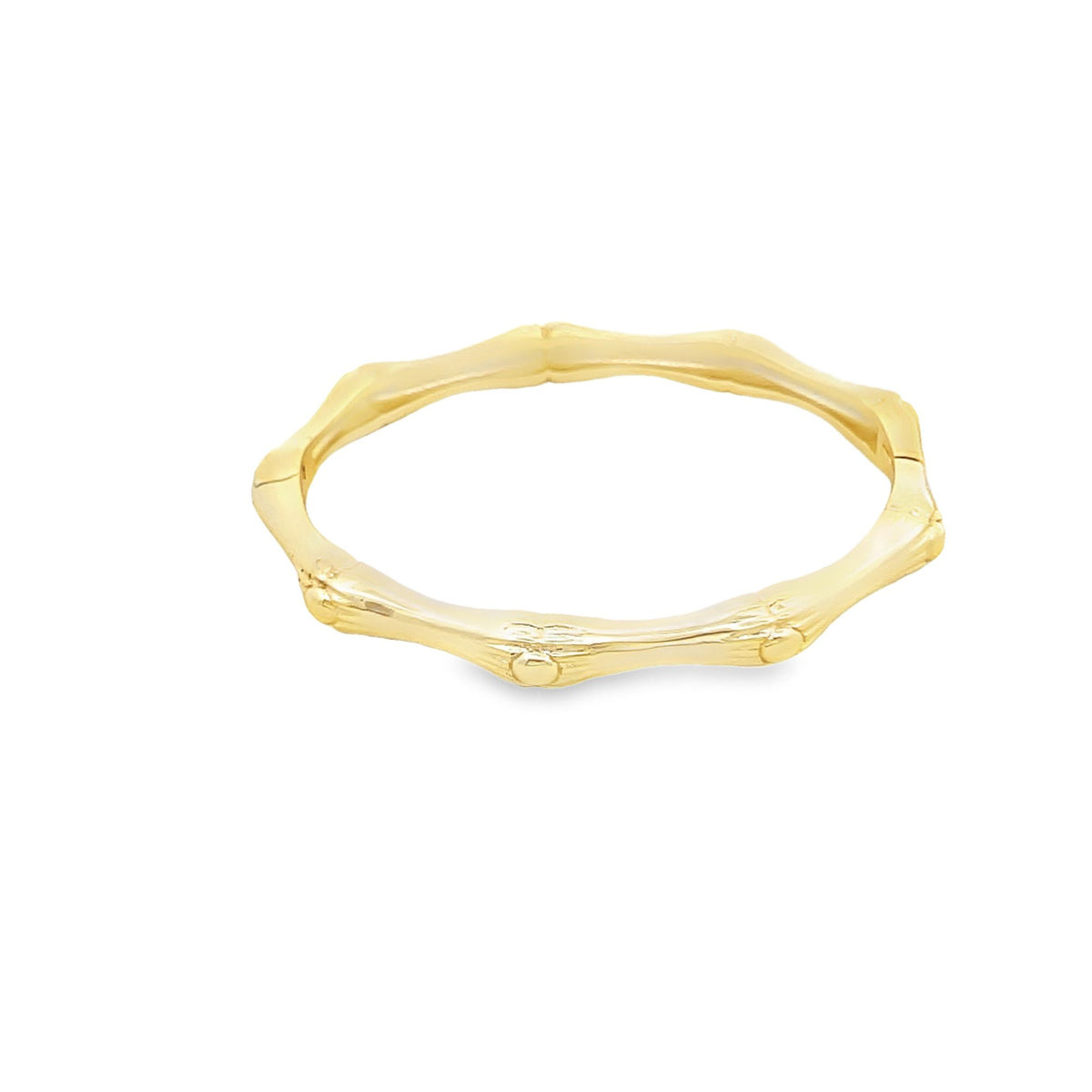 A shiny gold bamboo-shaped bangle bracelet rests against a clean white background.