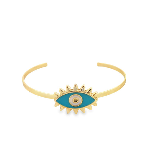 A gold cuff bracelet features a vibrant blue and white enamel evil eye charm with sunburst rays.