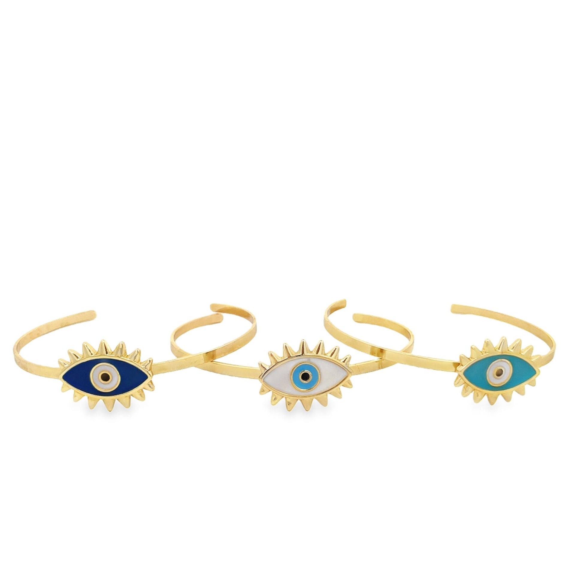 Three gold evil eye cuff bracelets display vibrant blue, white, and turquoise enamel details against a white background.