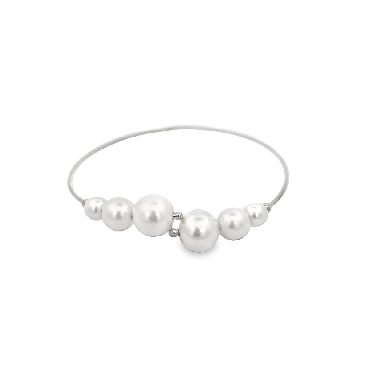 A delicate silver bangle bracelet features a graduated line of white pearls across the front.