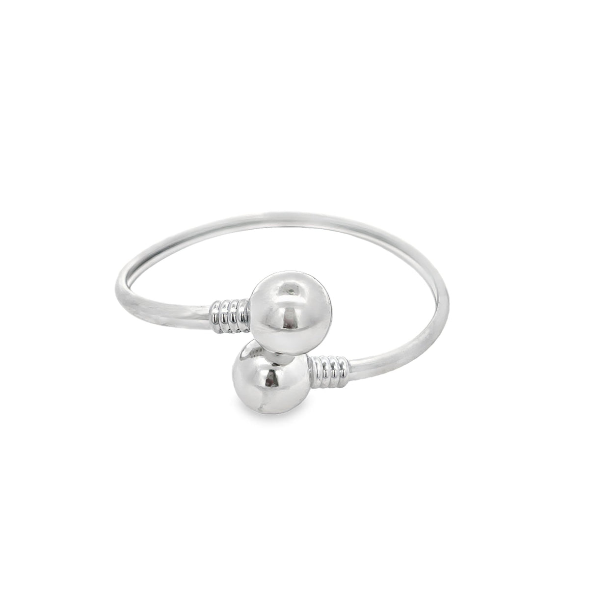 A polished silver bangle bracelet features two ball ends with ribbed details.