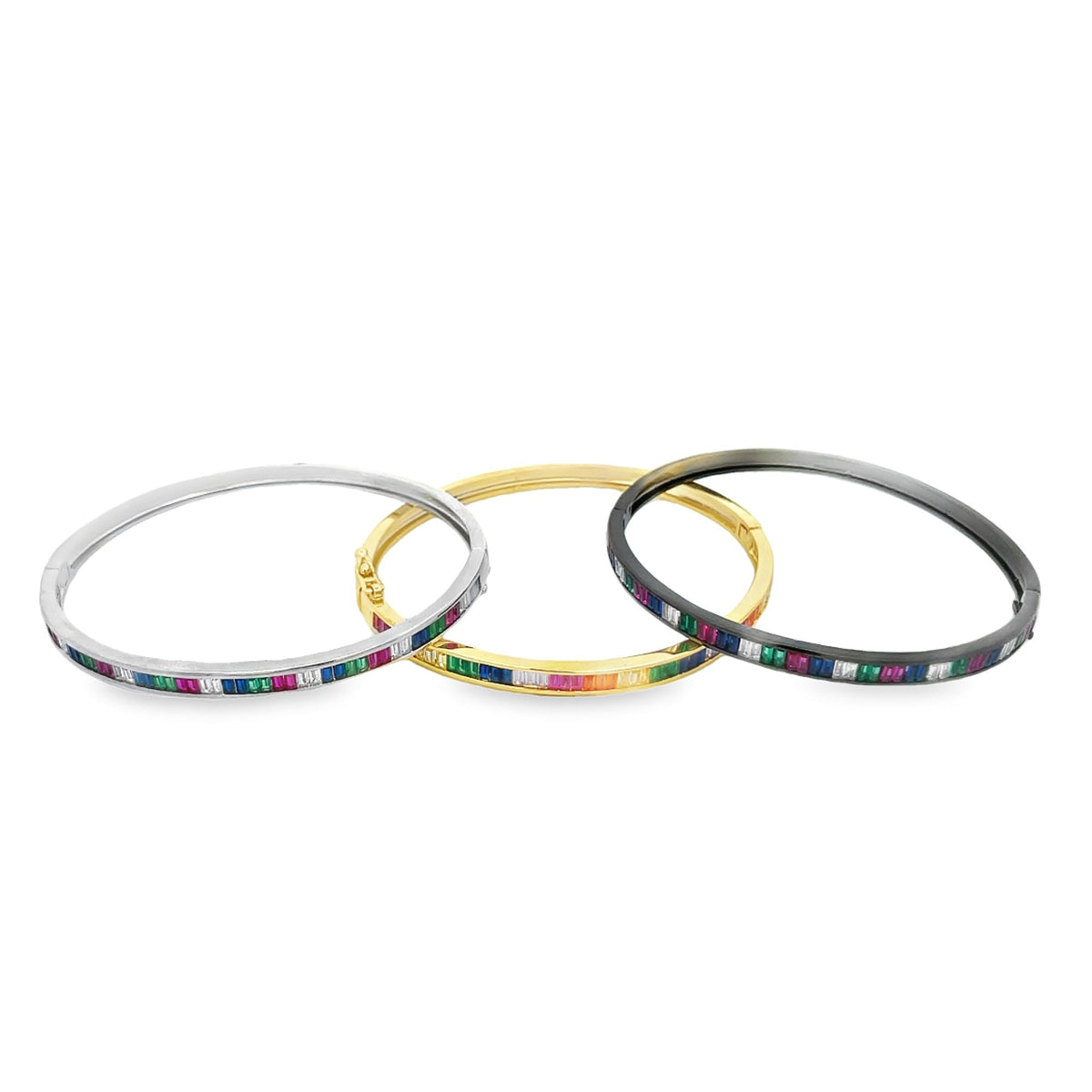 Three interlocking bangles in silver, gold, and black display channel-set multi-colored rainbow gemstones against a clean white background.