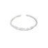 A minimalist silver ring featuring an open band with a delicate, wavy design rests against a clean white background.