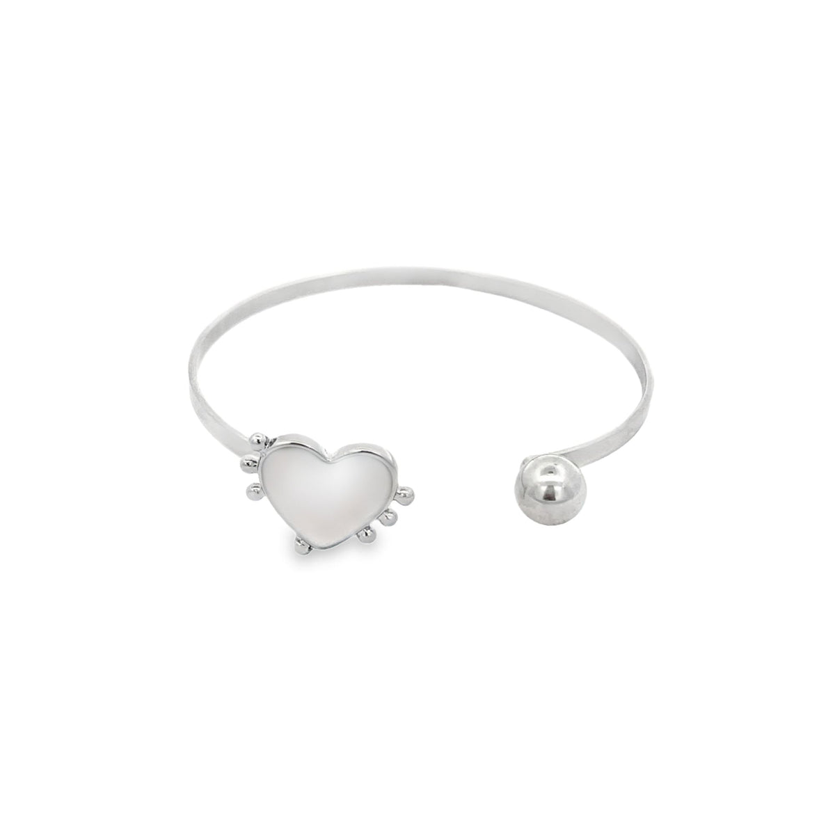 A silver cuff bracelet features a mother-of-pearl heart charm on one end and a polished ball on the other.