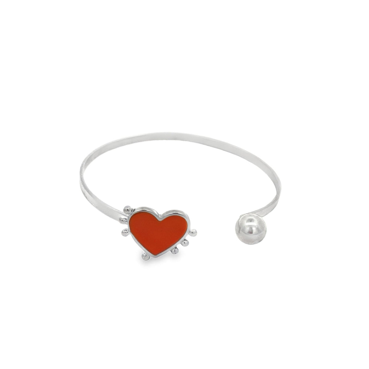 A silver cuff bracelet features a red enamel heart charm and a small ball terminal.