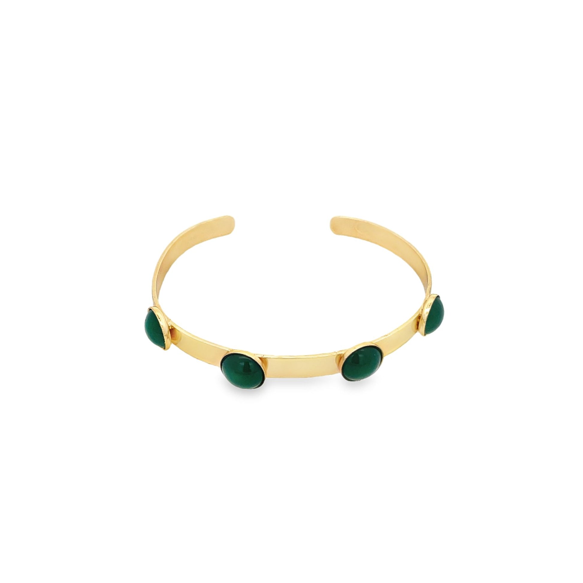 A sleek gold cuff bracelet features four polished green cabochon stones evenly spaced along the band.