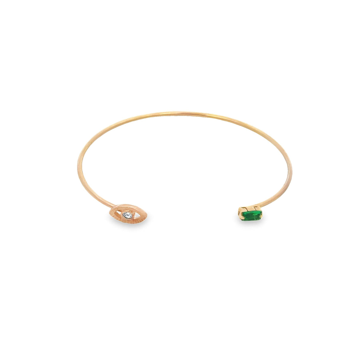 A delicate gold cuff bracelet features an evil eye motif set with a sparkling diamond on one end and a vibrant emerald gemstone on the other.