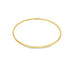 A minimalist gold bangle bracelet rests on a clean white background.
