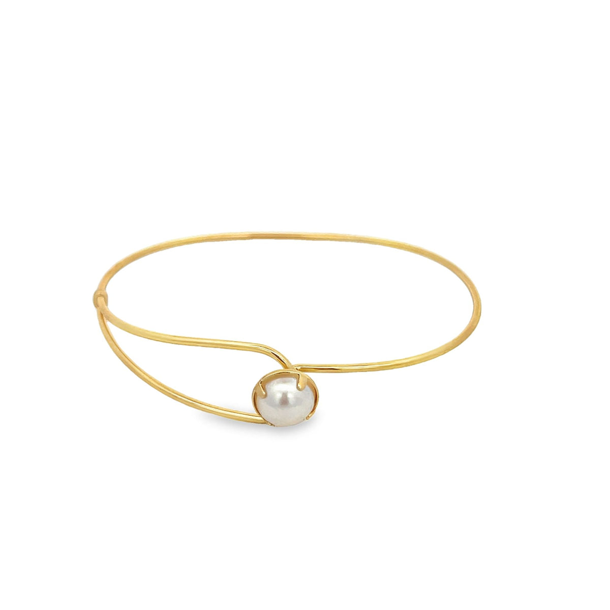 A minimalist gold bangle bracelet features a single lustrous pearl set seamlessly in the center against a clean white background.