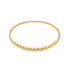 A delicate gold beaded bracelet displays a line of textured spheres curving gently against a plain white background.