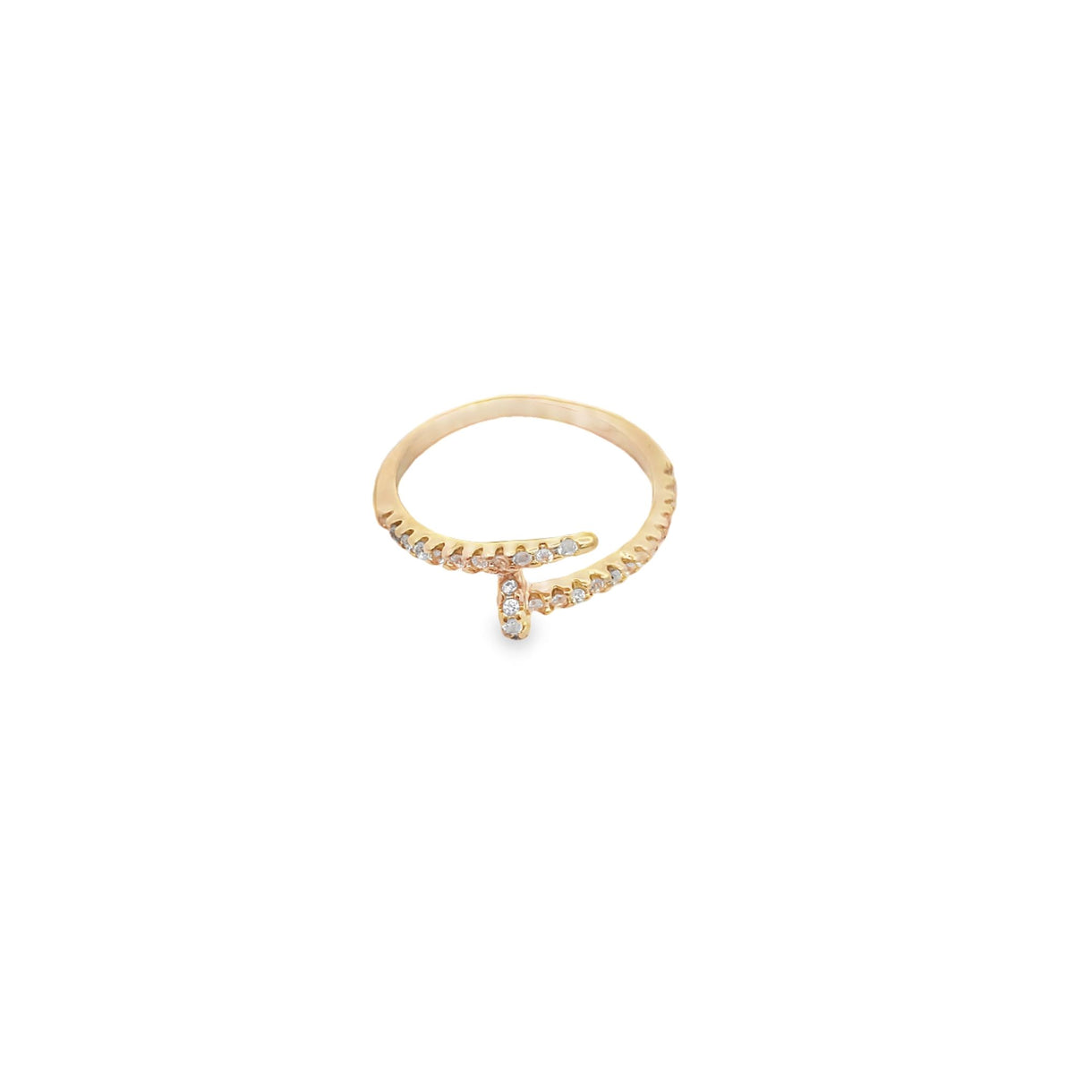 A delicate gold ring featuring a sparkling diamond-encrusted nail design rests against a clean white background.