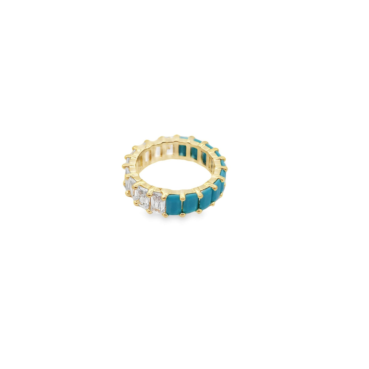 A gold eternity band features alternating baguette-cut cubic zirconia and vibrant turquoise stones against a clean white background.