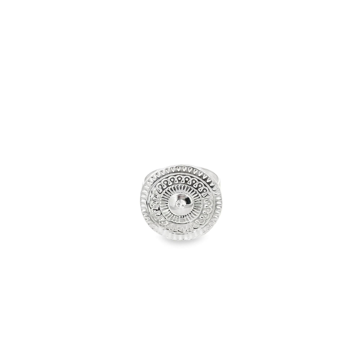 A silver statement ring features an intricate mandala-inspired circular design with engraved patterns against a plain white background.