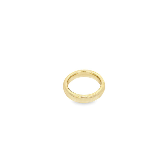 A simple, polished gold wedding band rests against a clean white background.
