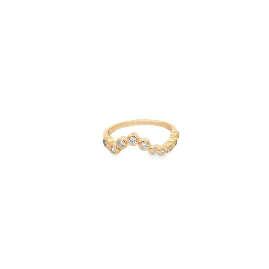 A delicate yellow gold bezel-set diamond band features a curved, staggered design against a clean white background.