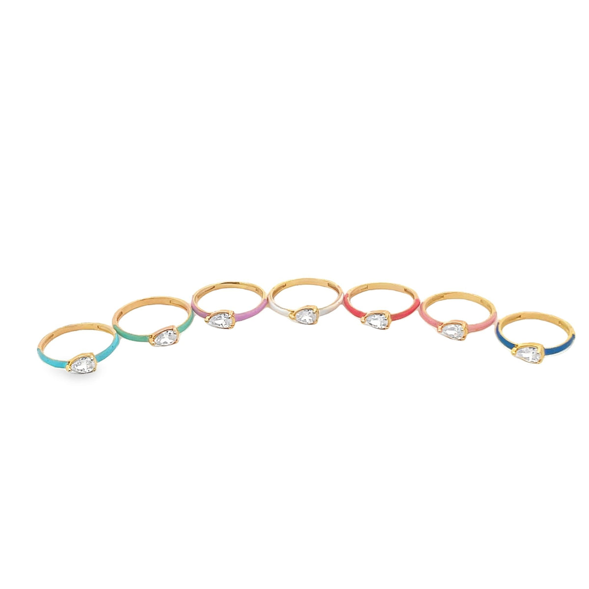 Seven colorful enamel gold rings featuring pear-shaped cubic zirconia stones rest in a row on a white background.