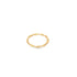 A minimalist twisted gold band ring rests on a plain white background.
