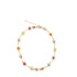 A gold-toned chain anklet features bezel-set multicolored gemstones arranged in a circular shape against a white background.