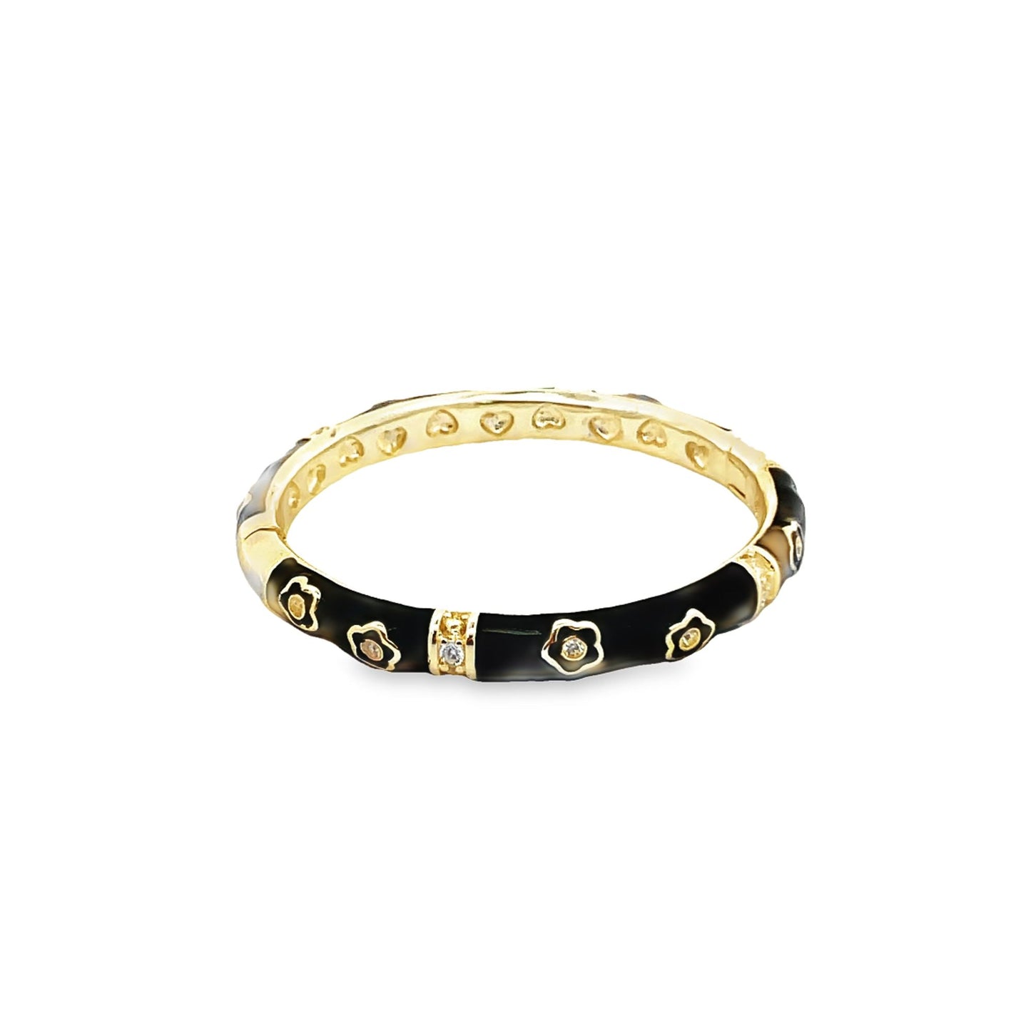 A gold and black enamel ring features sparkling diamond flower motifs and a heart-patterned inner band.