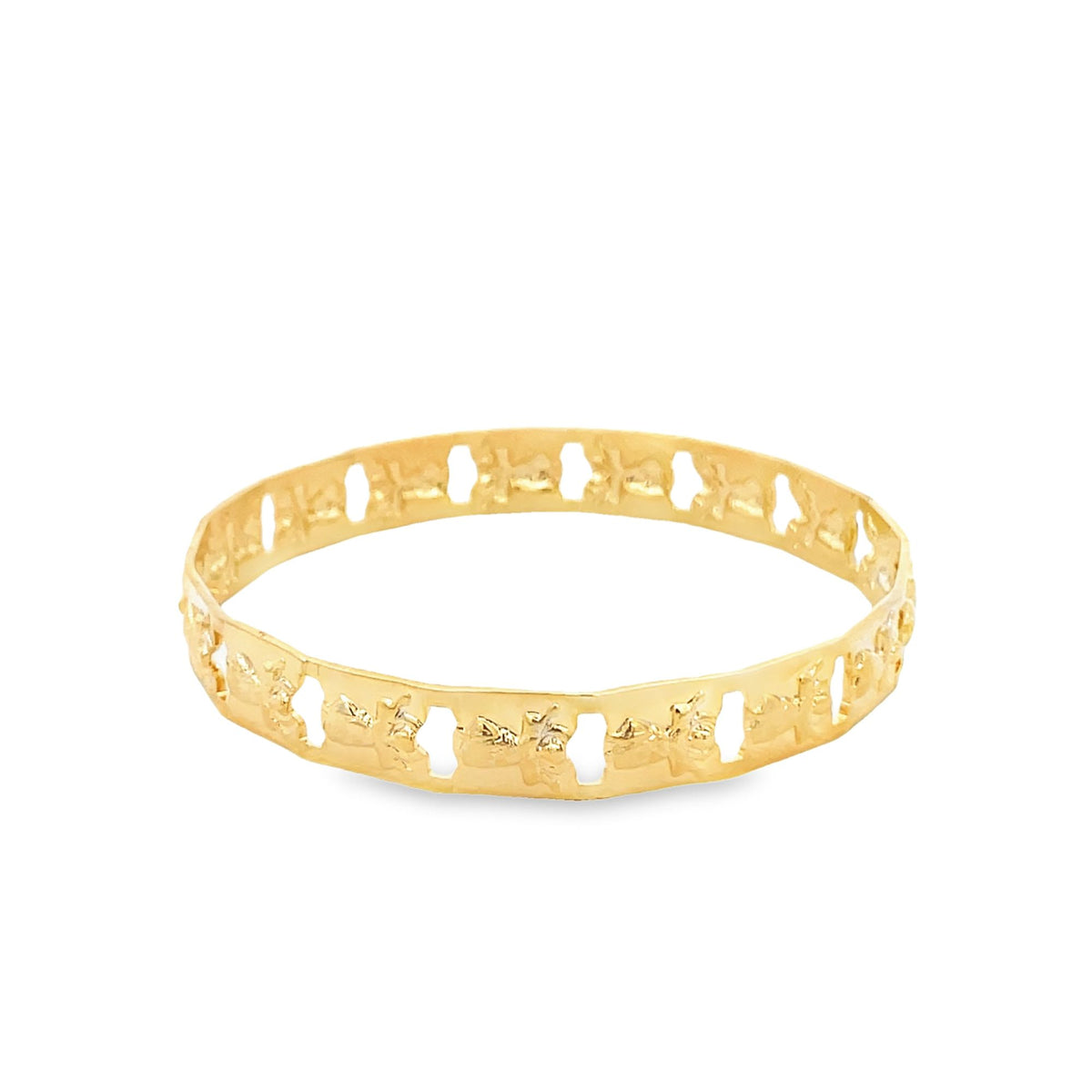 A polished gold bangle features intricate cut-out patterns along its band against a plain white background.