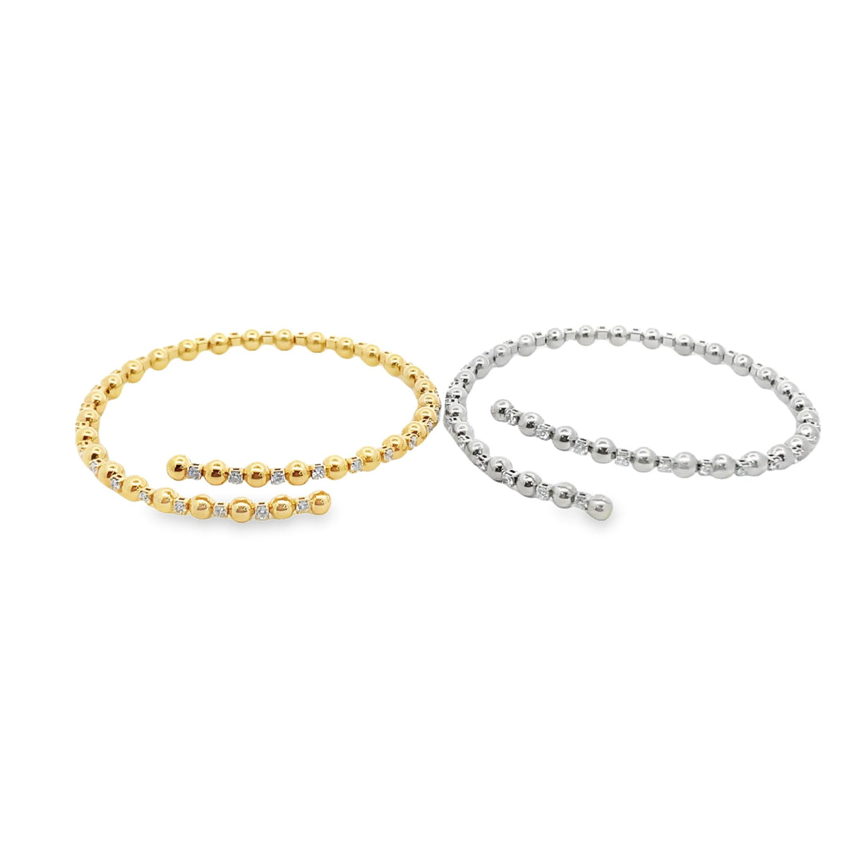 A yellow gold and a white gold beaded bypass bracelet sparkle against a plain white background.
