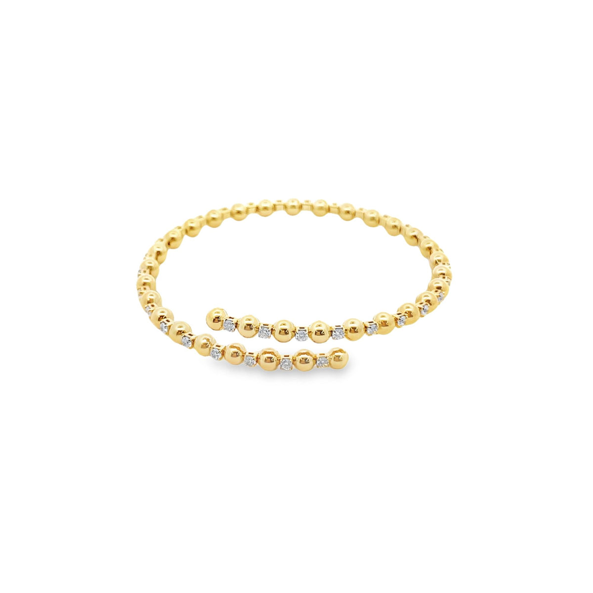 A delicate yellow gold bypass ring features alternating polished gold beads and sparkling diamond accents arranged in a wrap-around design.