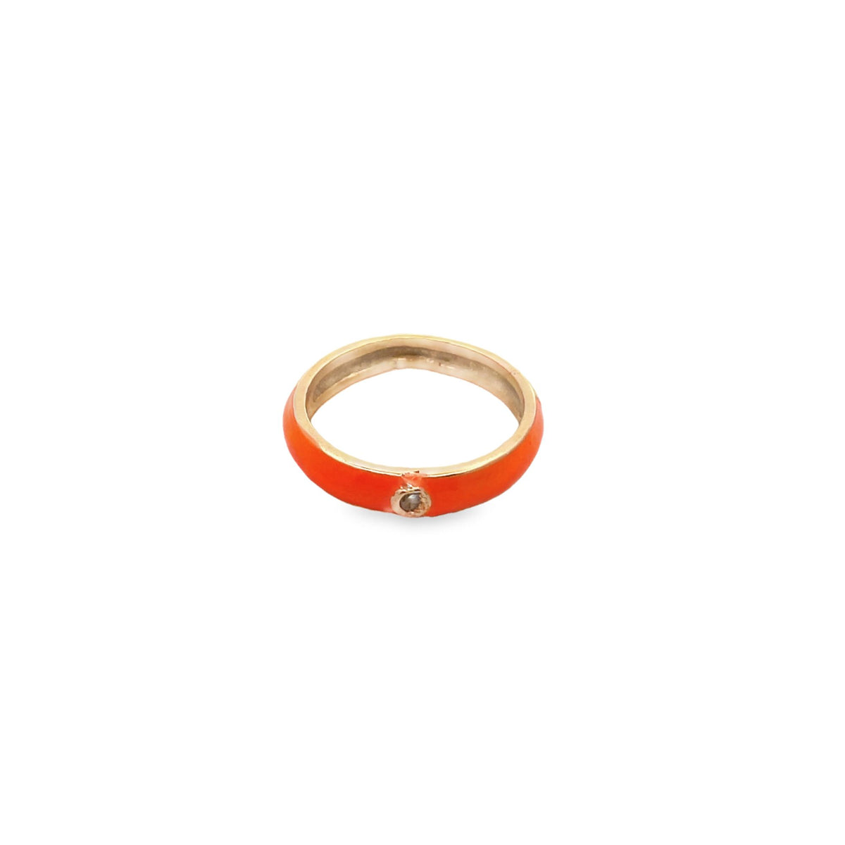 A vibrant orange enamel band ring features a single glittering diamond set in polished gold against a clean white background.