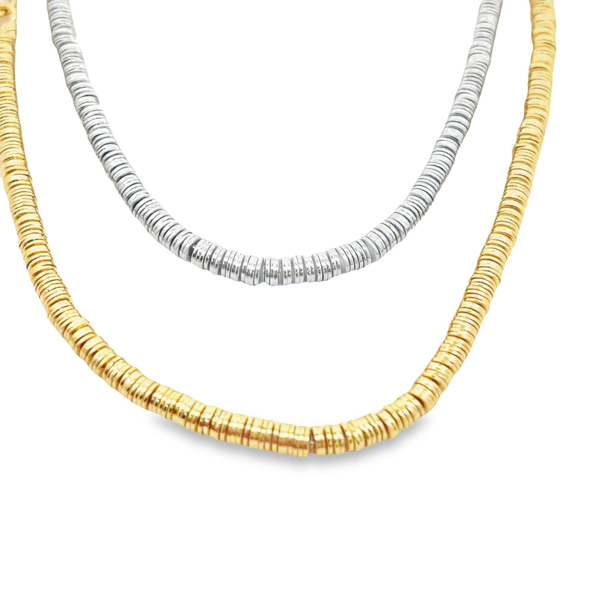 A layered set of two dainty beaded disk necklaces in contrasting gold and silver finishes rests against a clean white background.
