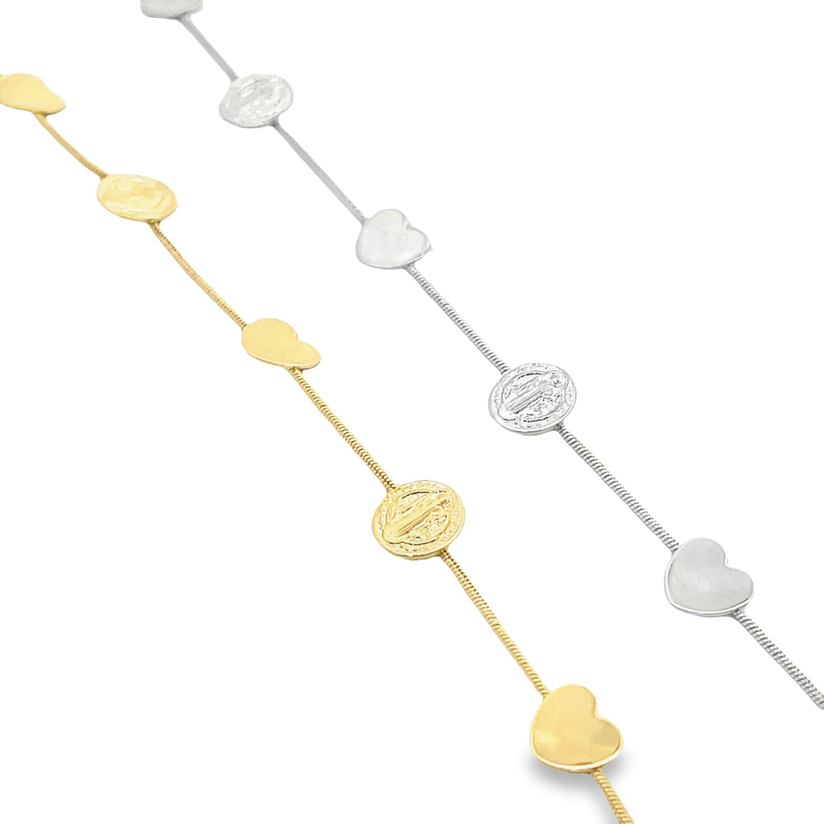 Two delicate chains, one in gold and one in silver, display alternating heart charms and religious medals against a white background.