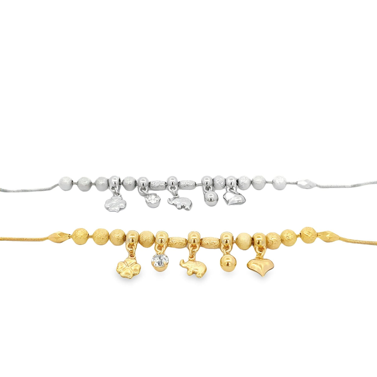 Two charm bracelets featuring textured beads and hanging charms of a clover, a gem, an elephant, a sphere, and a heart are displayed, one in silver and the other in gold.