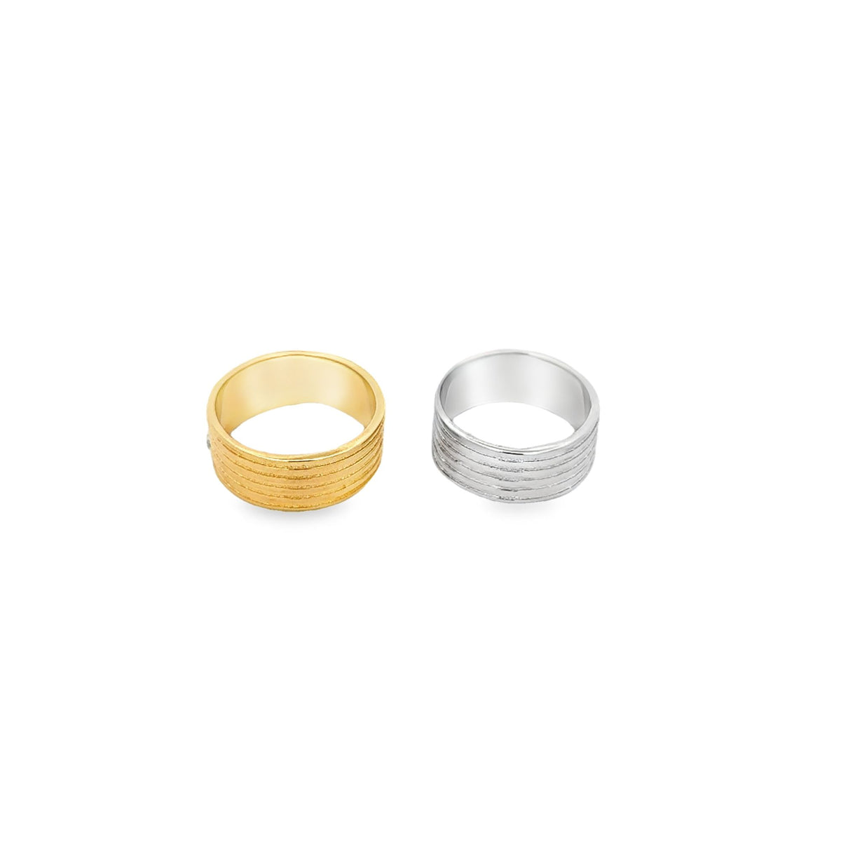 A gold ring and a silver ring with textured horizontal bands sit side by side against a clean white background.