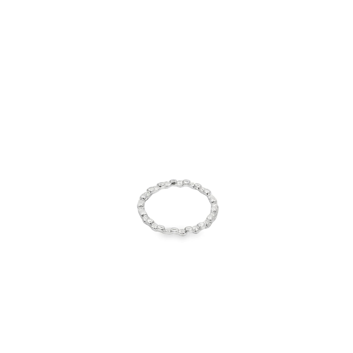 A delicate silver ring featuring a textured, pebble-like design rests against a clean white background.