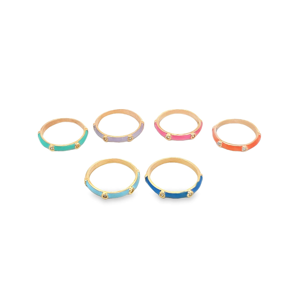 Six colorful enamel rings featuring gold bands and sparkling stones sit arranged on a white surface.