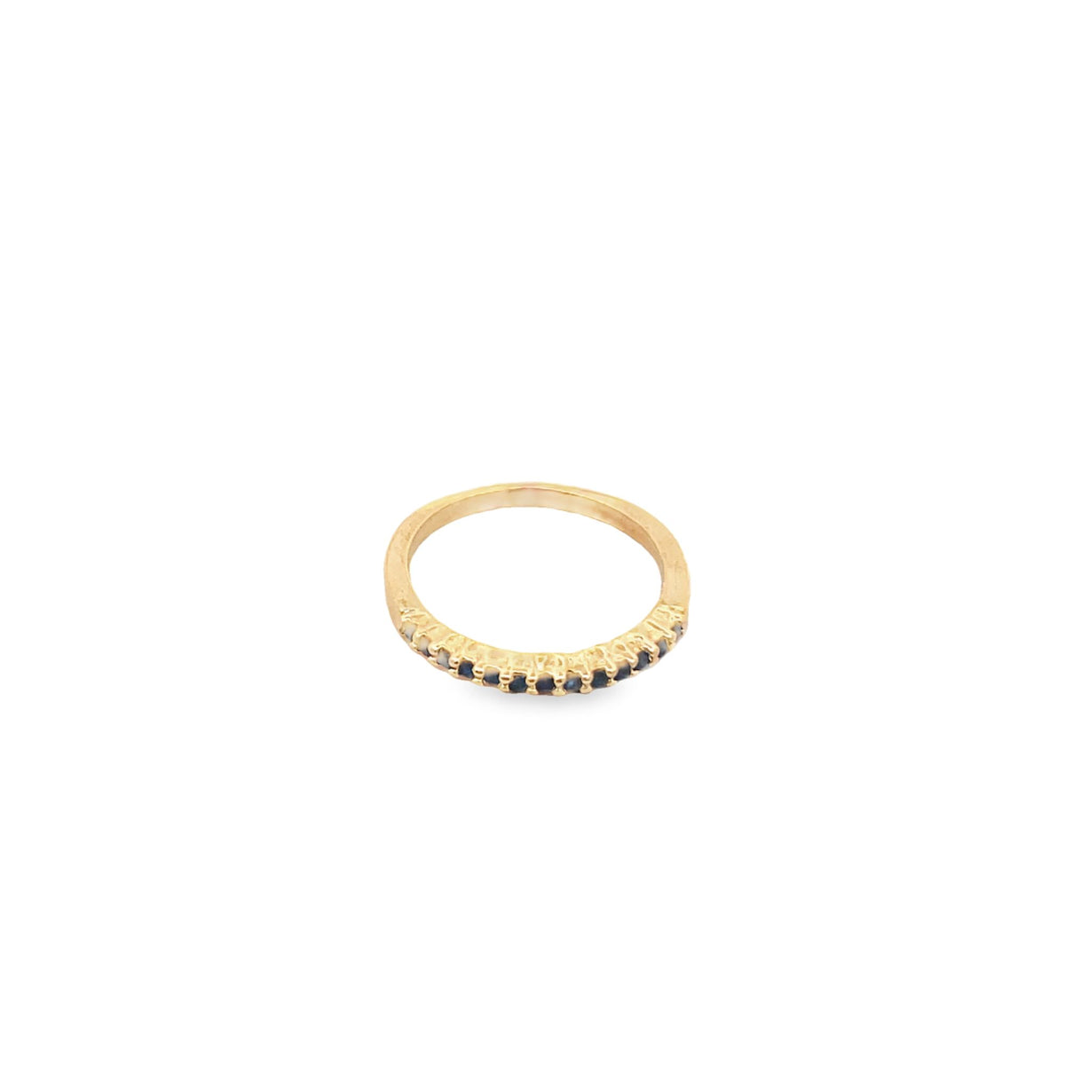 A gold band ring showcases a delicate row of dark gemstones embedded along its front against a clean white background.