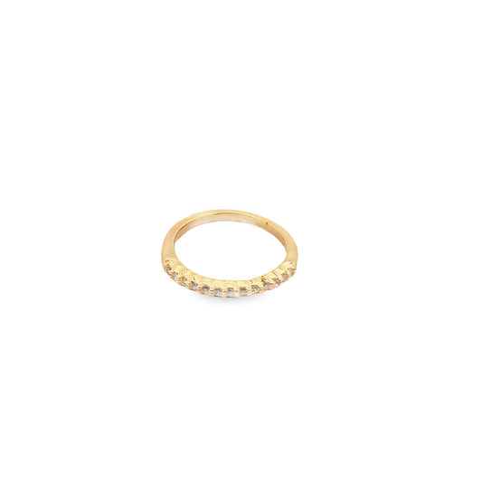 A delicate gold band ring sparkles with a row of small, embedded diamonds against a plain white background.