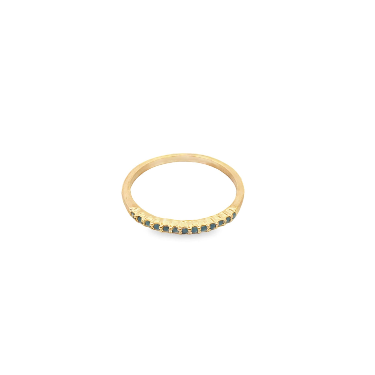A delicate gold ring features a row of small blue gemstones inlaid along the front band against a clean white background.
