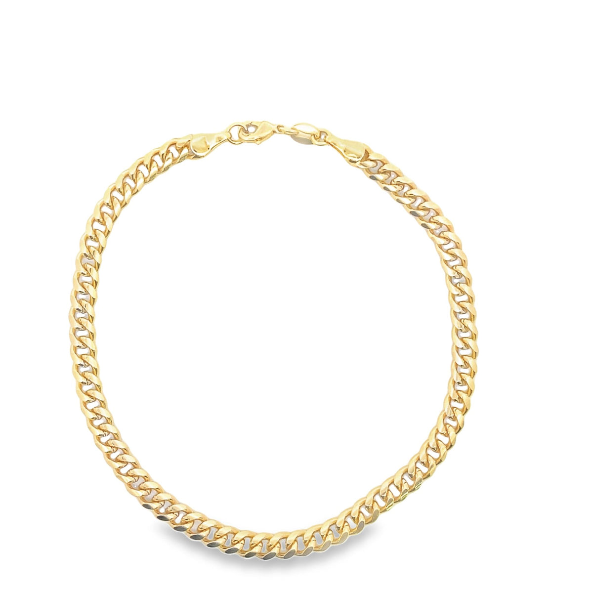 A shiny gold curb chain necklace rests in a circular loop against a plain white background.