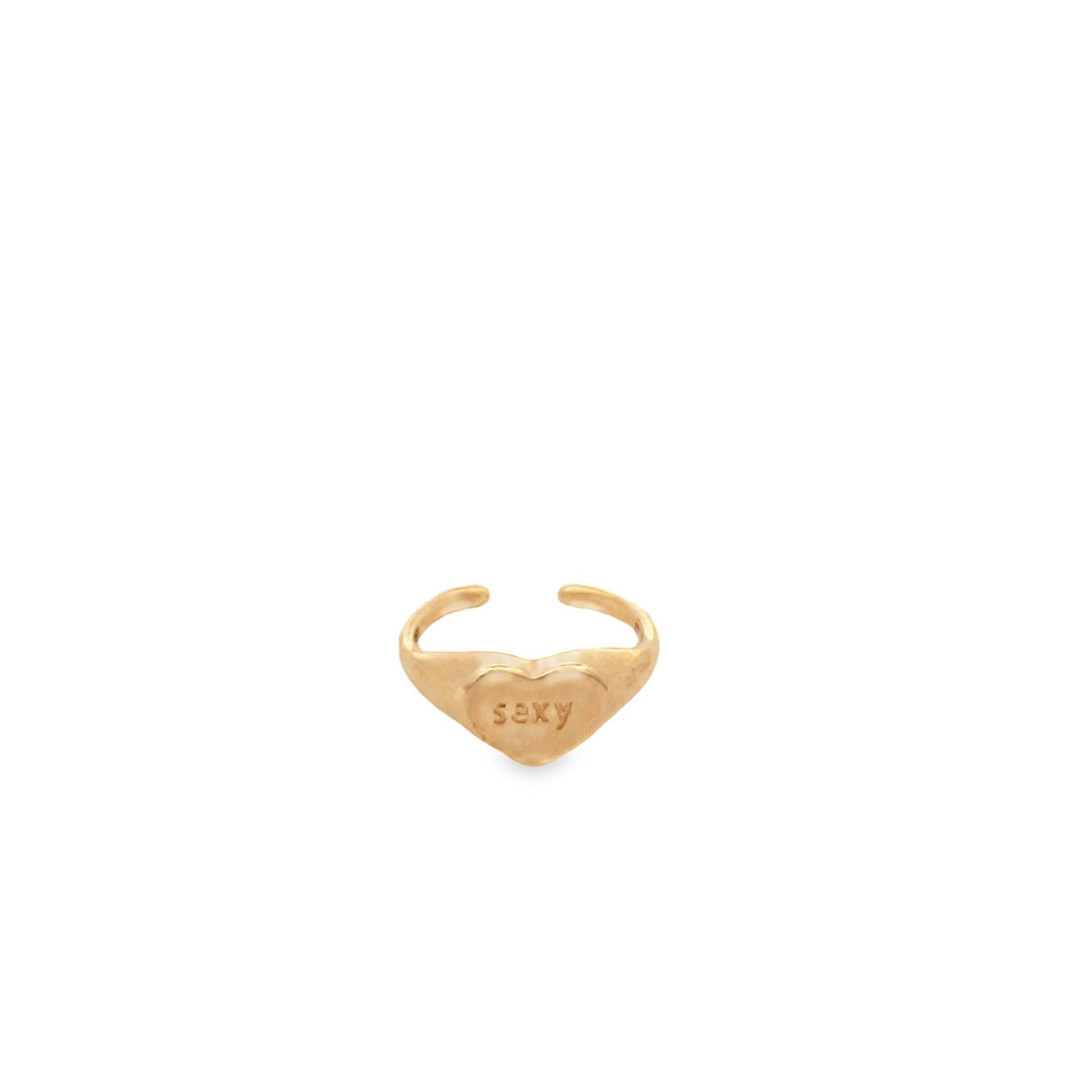A gold heart-shaped signet ring features the word "sexy" engraved on its face against a clean white background.