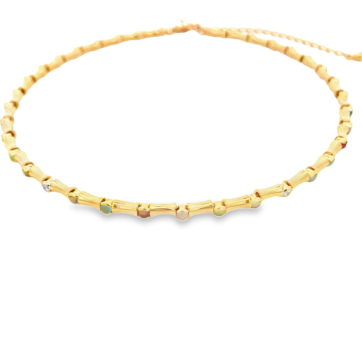 A delicate gold bamboo choker necklace sparkles against a clean white background, showcasing interspersed colorful gemstones.