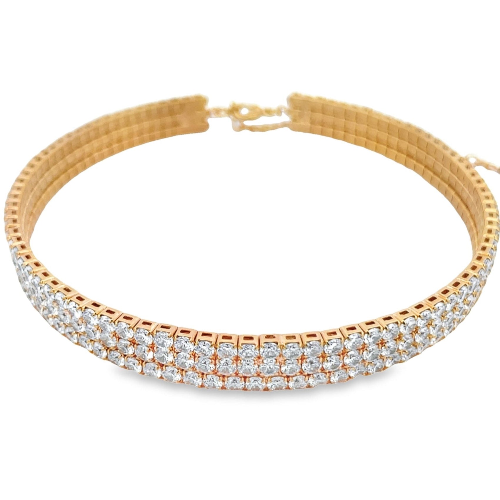 A sparkling double-row diamond tennis bracelet crafted in yellow gold rests on a clean white surface.