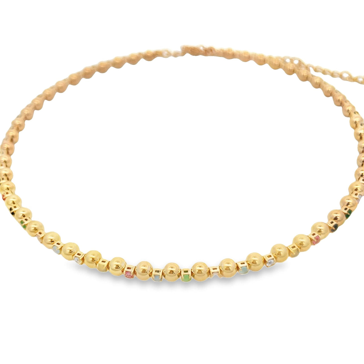 A delicate gold beaded choker necklace features alternating small golden spheres and colorful gemstones arranged along the chain.