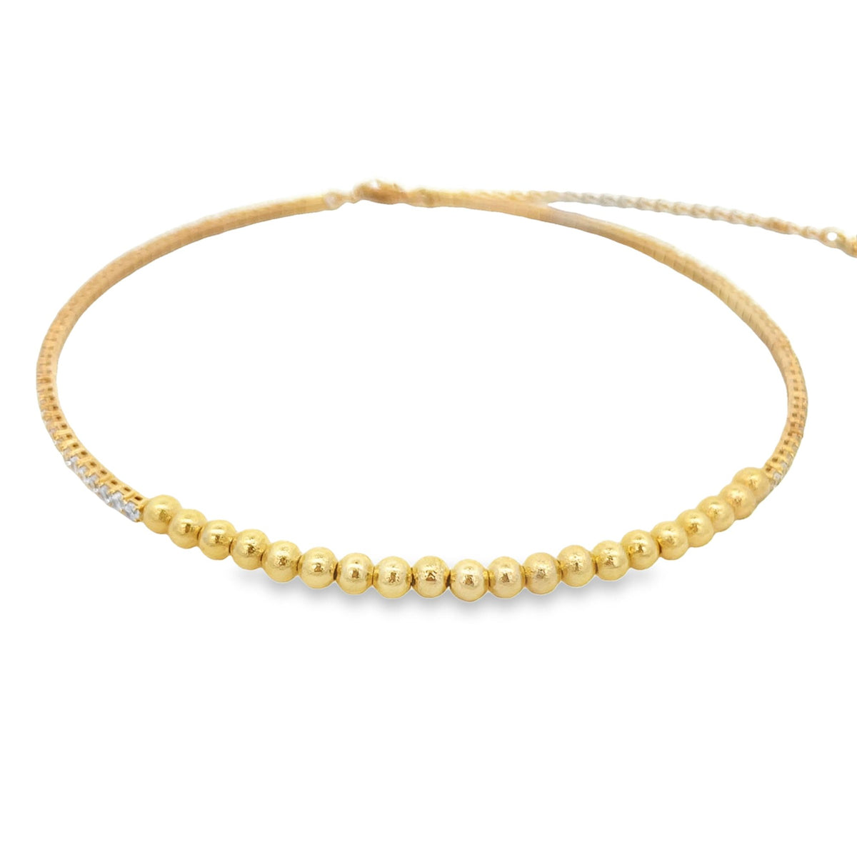 A delicate gold choker necklace features a row of polished gold beads and a small section of sparkling diamonds.