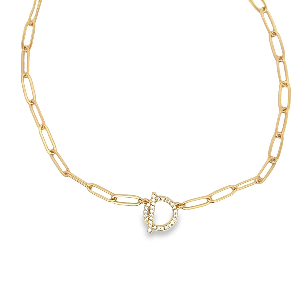 A gold paperclip chain necklace showcases a sparkling diamond initial D pendant centered on a plain white background.