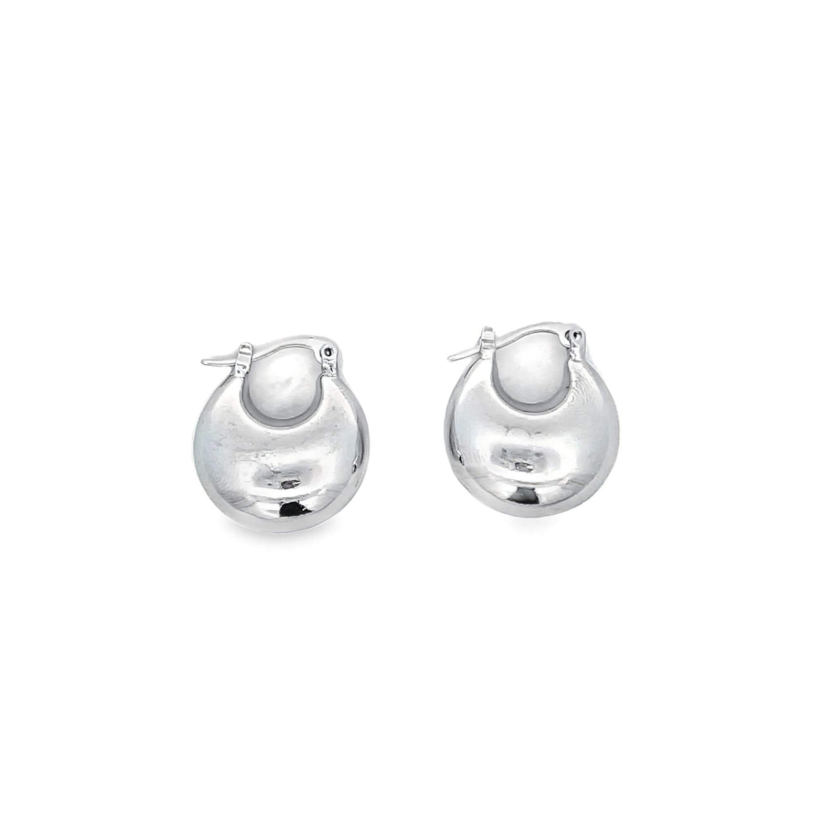 A pair of polished silver dome hoop earrings rests on a clean white surface.