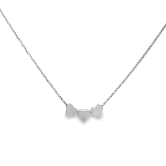 A delicate silver box chain necklace features three small heart charms hanging together as a pendant.