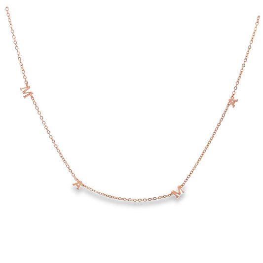 A delicate rose gold MAMA letter necklace drapes against a clean white background.