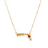 A delicate gold necklace features a pendant shaped like a wine bottle pouring red wine into a glass.